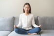 © Pormezz - Wellbeing peaceful mind lifestyles,  Close up hand of young Asian women focus on breath harmony to refresh mindfulness on sofa in the living room at home.