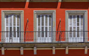 Wall Mural - Close up of houses on Plaza Mayor square surrounded by cafes and restaurants along the arches with Philip III statue created in 1616, Madrid, Spain