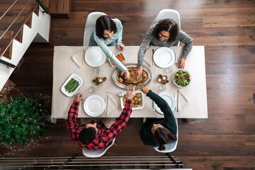 Wall Mural - Top view of family toasting with champagne before Christmas dinner.