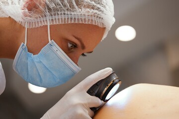 A dermatologist examines the skin.