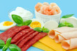 Proteinreiche Ernährung mit Fleisch, Käse, Ei, Joghurt und Shrimps auf blauem Hintergrund