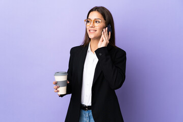 Sticker - Business woman isolated on purple background holding coffee to take away and a mobile