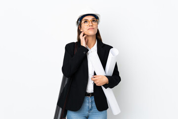 Wall Mural - Young architect caucasian woman with helmet and holding blueprints over isolated background thinking an idea