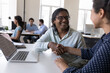 © fizkes - Happy Indian employees giving handshakes at shared workplace, laptop, expressing respect, recognition, thanking fir good job. Employer hiring candidate after successful interview, test