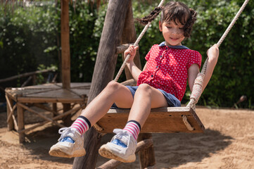 Asia kids girl play swing on play ground in the park	