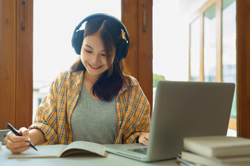 Wall Mural - Education and literacy concept, College student girl is listening lecture online and taking notes