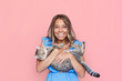 © Марина Демешко - Young attractive caucasian cute blonde woman in a blue dress holds a cat in her hands like a baby isolated on a light color pink background. The girl babying with a kitten. Fiendship of pet and owner