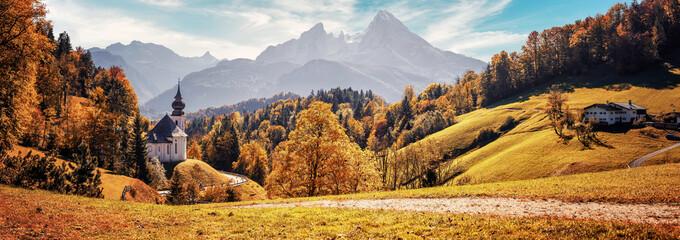 Fototapete - Stunning Autumn landscape. Scenic view on Maria Gern church with mountains on background. Vivid atmospheric nature scenery. Natural background. Iconic location for landscape photographers..Formats