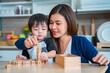 © P Stock - Mother playing dice with her adorable little son in the kitchen.
