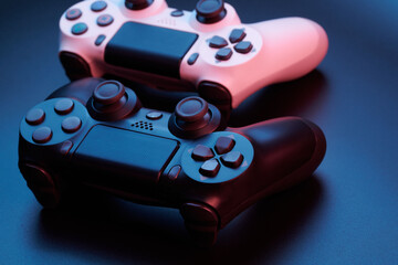 Two video game controllers, joysticks for game console isolated on black background. Gamer controlling devices close-up