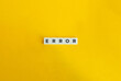 © photoopus - Error Word on Block Letter Tiles on Yellow Background. Minimal Aesthetics.
