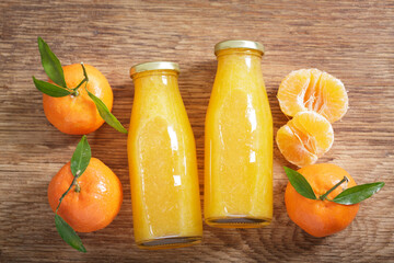 Wall Mural - Bottles of mandarin juice with fresh fruits, top view