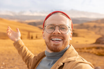 Wall Mural - Happy hiker man making selfie photo portrait on top of mountain. Concept adventure life