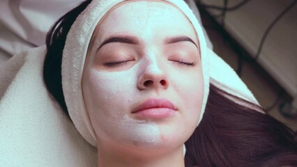 Wall Mural - Close-up shot of a woman getting facial treatment with clay mask. Cosmetology and spa