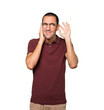 © agongallud - Concentrated young man making a gesture of trying to hear something