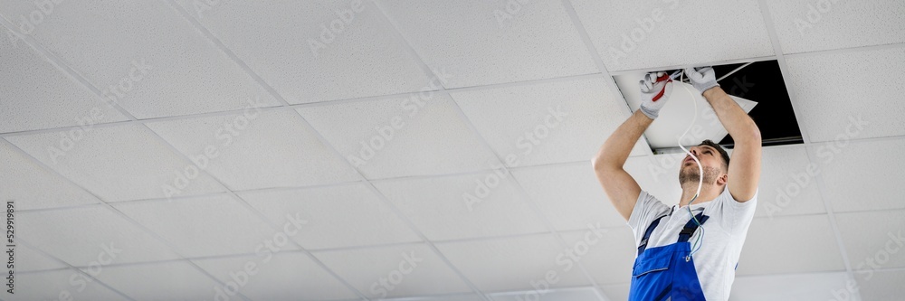 Electrician On Stepladder Installs Lighting To The Ceiling Stock Photo ...