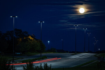 Wall Mural - Bright moon over highway with street lights and trails of passing cars