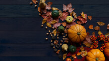 Thanksgiving Wallpaper With Autumn Leaves, Gourds And Pine Cones On A Dark Wood Tabletop.