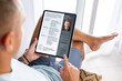 © Kaspars Grinvalds - Man looking at his CV document on tablet computer to apply for a new job