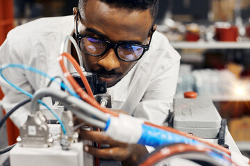 Wall Mural - african engineer programming equipment with tablet at factory