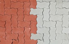 Red And Gray Interlocking Concrete Paver Blocks. Irregular Shaped Tiles For Outdoor Pavement. Samples. Background And Texture