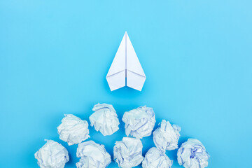 Wall Mural - Paper plane and crumpled paper on blue background, Concept of idea, innovation and Inspiration