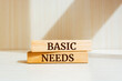 Wooden blocks with words 'Basic needs'. Business concept