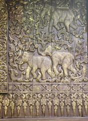 Wall Mural - Detail of ancient wooden carved wall  with traditional  ornament and elephants, Thailand