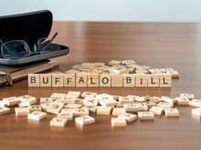 Buffalo Bill Word Or Concept Represented By Wooden Letter Tiles On A Wooden Table With Glasses And A Book