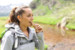 © Antonioguillem - Happy hiker eating a cereal bar in the mountain