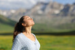 © Antonioguillem - Relaxed woman breathing fresh air in the mountain a sunny day