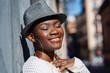© Westend61 - Smiling woman with eyes closed wearing hat and hoop earrings