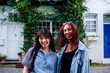 © Westend61 - Happy friends standing together in front of building
