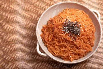 Wall Mural - Korean instant noodles with spicy sauce sprinkled with seaweed