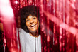 © Westend61 - Cheerful woman amidst red tinsels enjoying party