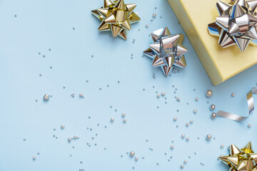 Wall Mural - flat lay christmas and new year gift boxe, pearls and bows top view on blue festive background