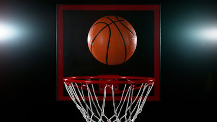 Detail of basketball ball hitting the basket.