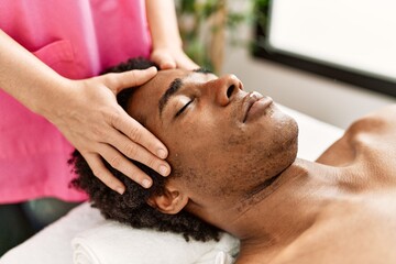 Sticker - Young african american man having face massage at beauty center