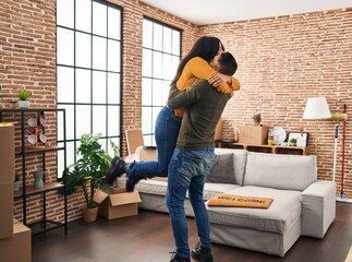 Canvas Print - Man and woman couple hugging each other standing at new home