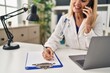 © Krakenimages.com - Middle age blonde woman wearing doctor uniform talking on the smartphone at clinic