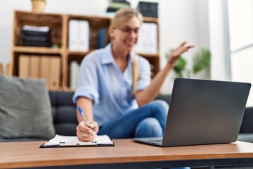 Young blonde woman having psychology online session at clinic