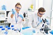© Krakenimages.com - Man and woman wearing scientist uniform using pipette and microscope working at laboratory