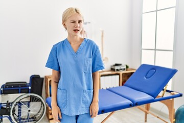 Canvas Print - Beautiful caucasian physiotherapist woman working at pain recovery clinic winking looking at the camera with sexy expression, cheerful and happy face.