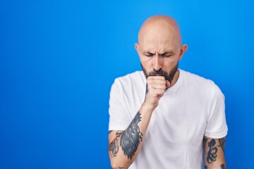 Poster - Hispanic man with tattoos standing over blue background feeling unwell and coughing as symptom for cold or bronchitis. health care concept.