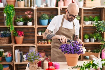 Poster - Young bald man florist cutting plant at florist