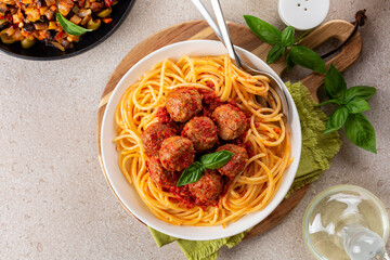 Wall Mural - Italian American dinner. Spaghetti and beef Meatballs with tomato sauce and Sicilian caponata with fried eggplants and other vegetables. Olive oil. Top view.