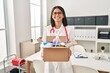 © Krakenimages.com - Young hispanic doctor woman holding box with medical items smiling with a happy and cool smile on face. showing teeth.