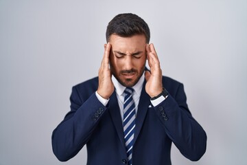 Wall Mural - Handsome hispanic man wearing suit and tie with hand on head, headache because stress. suffering migraine.