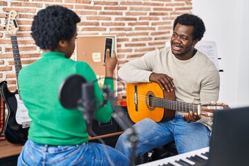 Poster - African american man and woman music group make photo holding spanish guitar at music studio