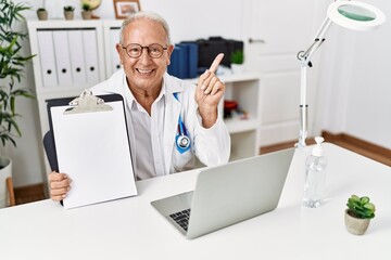 Sticker - Senior doctor man holding clipboard with blank space smiling happy pointing with hand and finger to the side